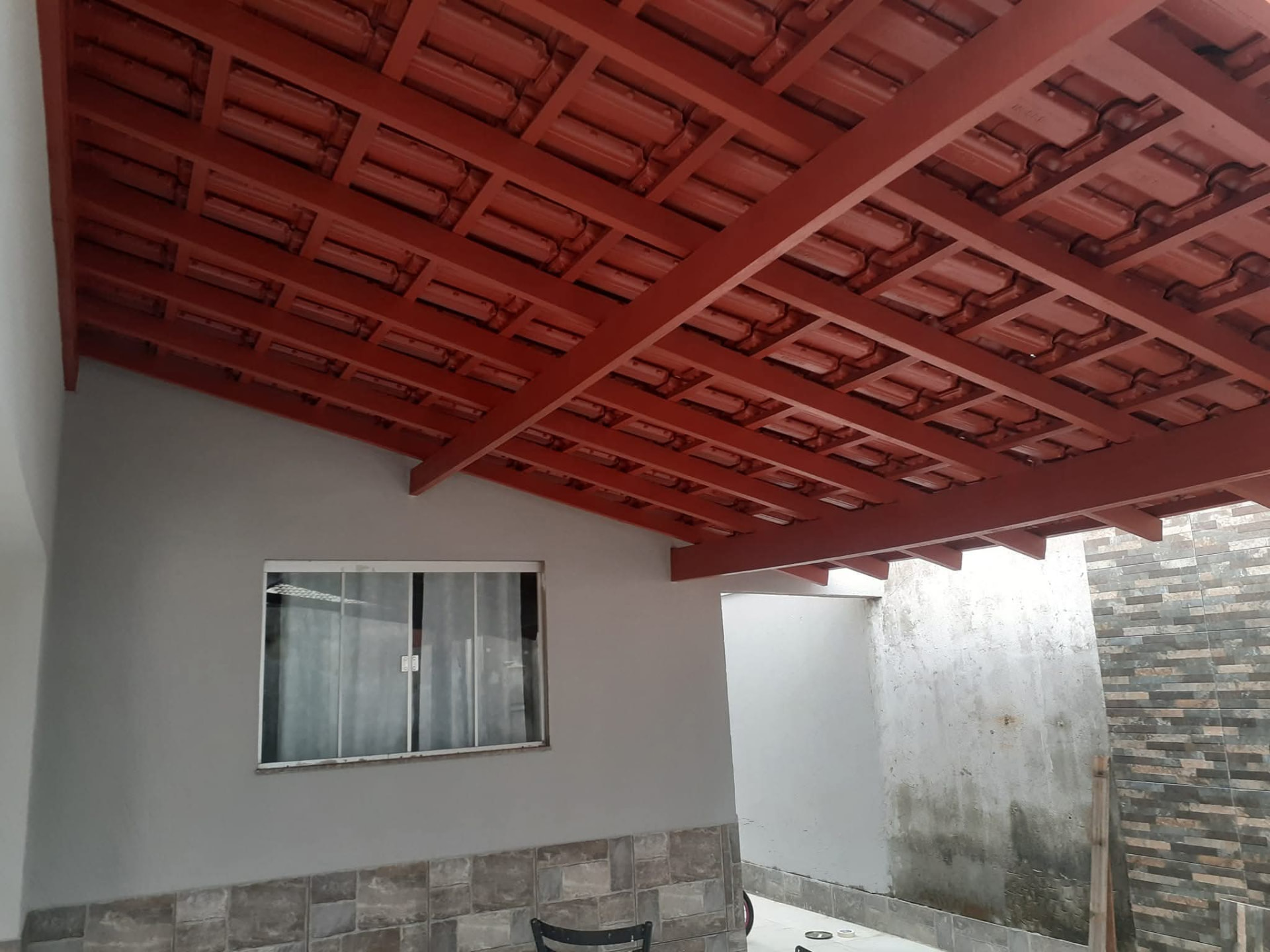 Varanda com madeiramento pintado em tom vermelho
