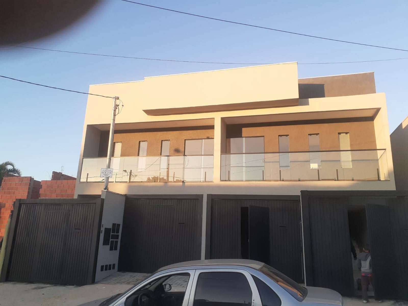 Fachada de sobrado pintada em tons claros e terrosos