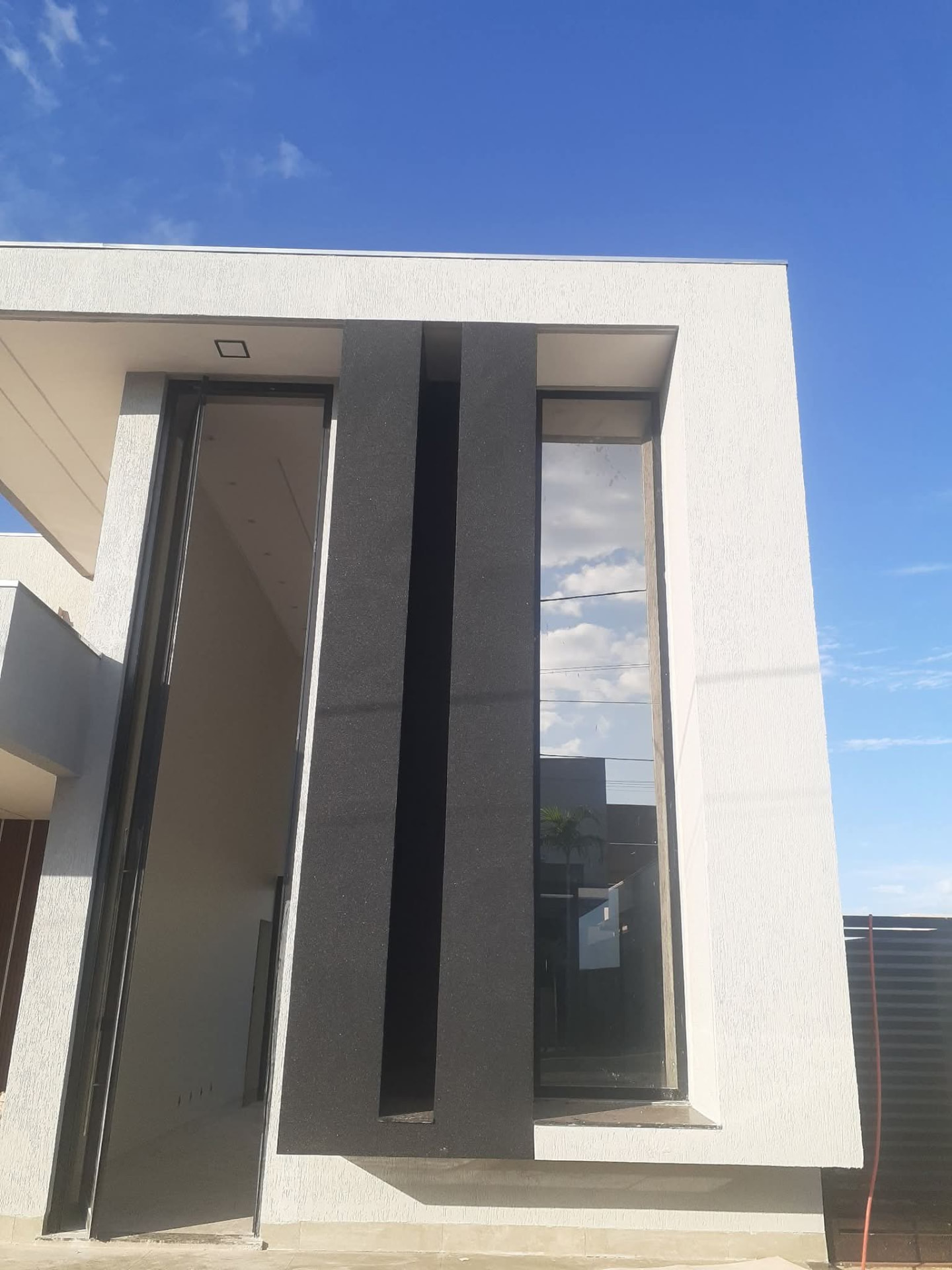 Fachada moderna branca com detalhe vertical preto